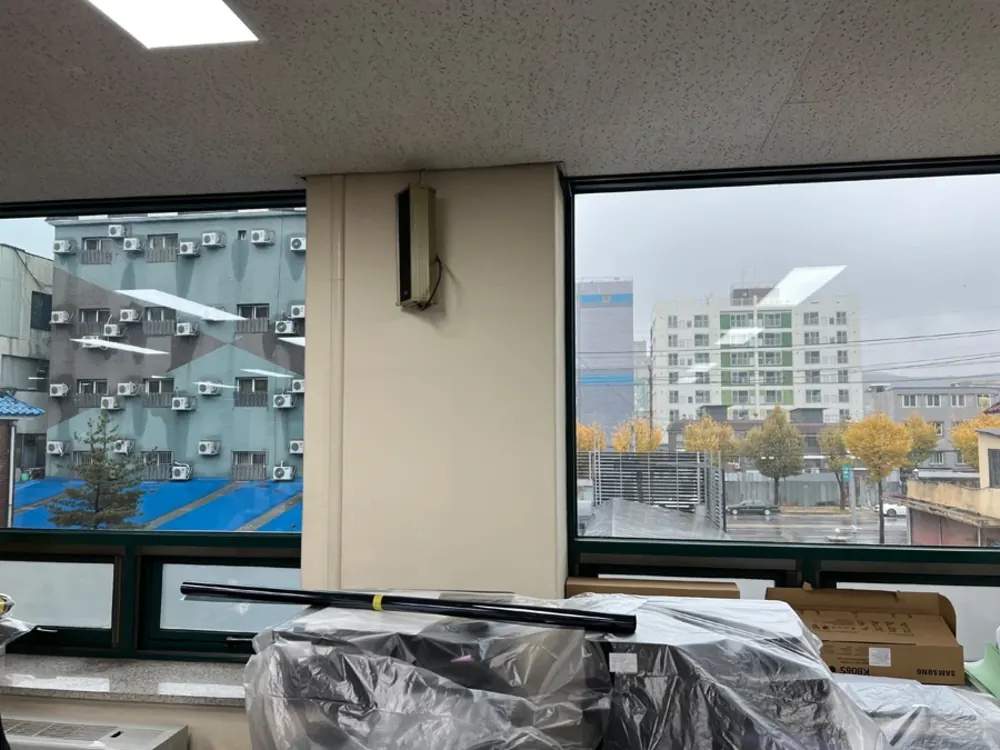 시공 전 필름 자재가 준비된 사무실 창가 전경