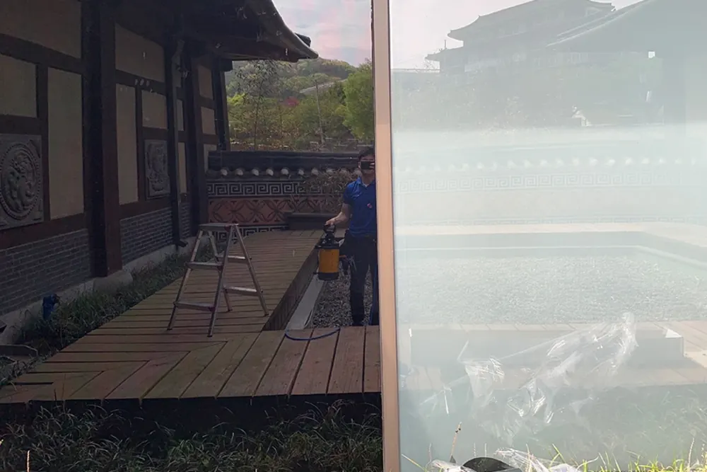 시공 전 유리 표면에 세정액을 분사하는 작업자