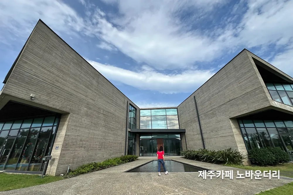 콘크리트 각진 외관과 대형 통유리로 이뤄진 복층 카페 전경