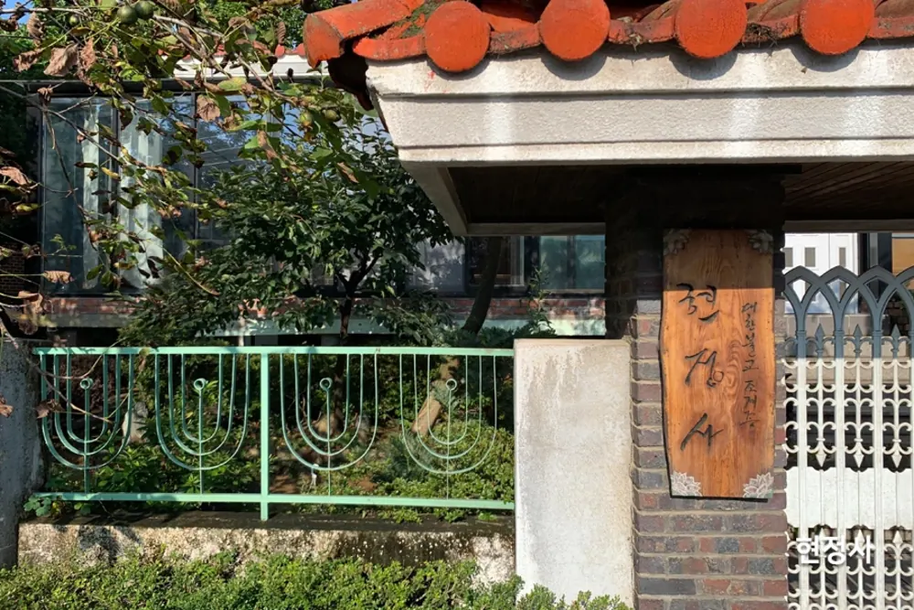 전통 기와 지붕과 현판이 걸린 사찰 입구 전경