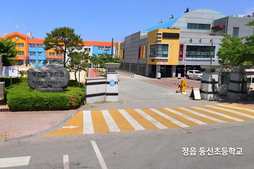 알록달록한 초등학교 건물과 정문 앞 횡단보도 전경